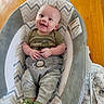 Wyatt is registered to the contest to win money with this photo: baby, infant, smiling, baby_rocker, green_shirt, gray_pants, dinosaur_slippers, chevron_pattern, wooden_floor, happy, cute, indoor, child, clothing, footwear, seated, portrait, comfort, toy, playful