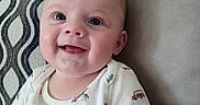 Wyatt joined the competition — help win amazing prizes! baby, smile, child, couch, pillow, indoor, person, infant, happy, face, pattern, clothing, plant, home, portrait, sitting, cute, young, skin, expression
