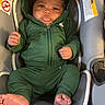 baby, infant, green_hoodie, car_seat, tongue_out, cute, child, smiling, clothing, seat_belt, indoor, infant_clothing, foot, hand, head, face, person, warning_label, fabric, soft