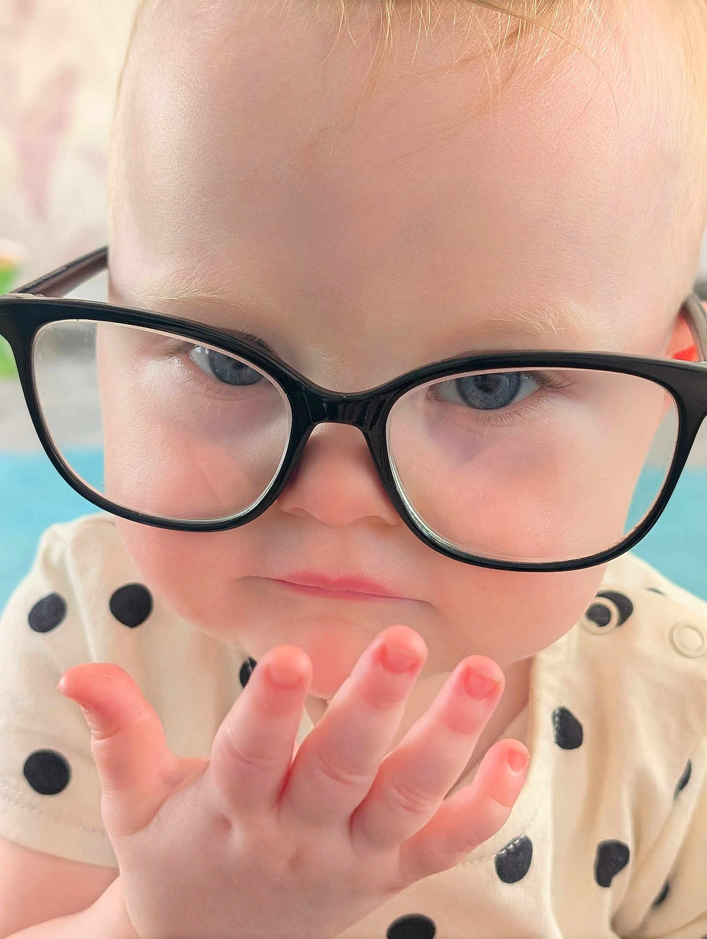 Aria joined the competition — help win amazing prizes! baby, child, glasses, face, hand, fingers, polka_dot, clothing, curious, blue_eyes, skin, portrait, close_up, indoor, young_child, expression, cute, infant, person, head
