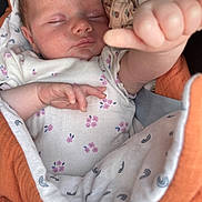 Lily a rejoint le concours — aidez-le/la à gagner de superbes lots ! baby, sleeping, thumbs_up, blanket, onesie, infant, hand, face, cozy, cute, resting, child, floral_pattern, newborn, soft, wrapped, peaceful, indoors, portrait, closeup