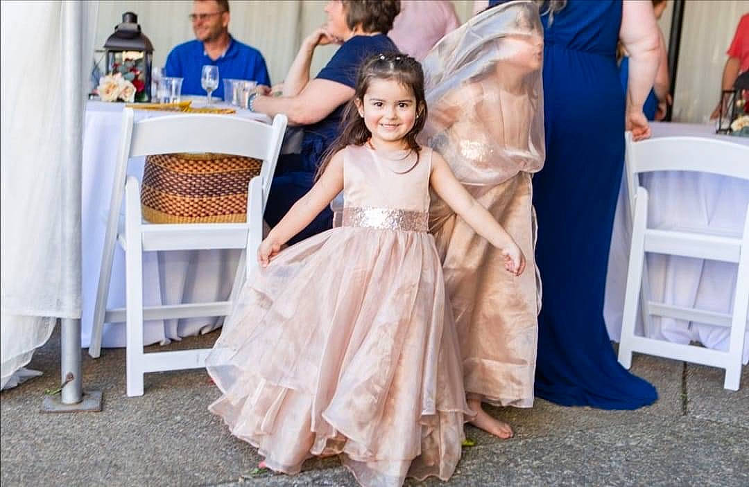 Jayde is registered to the contest to win money with this photo: arm, blue, blurred, bridal_accessory, bridal_clothing, bridal_party_dress, chair, clothing, dress, event, fashion_design, flooring, formal_wear, fun, gown, happy, joy, person, smile, toddler