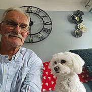 Thalia a rejoint le concours — aidez-le/la à gagner de superbes lots ! elderly_man, white_dog, glasses, striped_shirt, clock, wall_art, red_blanket, hearts_pattern, sofa, living_room, pet, smile, indoor, portrait, couch, furniture, white_hair, mustache, decor, companionship