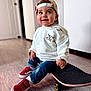 Augustin participe au concours pour gagner de l'argent avec cette photo : cap, casual_clothing, cheeky, child, cute, floor, footwear, happy, headwear, hoodie, indoor, jeans, person, playful, red_sneakers, skateboard, smiling, toddler, wooden_floor, young_child