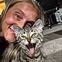 woman, cat, kitten, smiling, playful, carpet, indoor, close_up, pet, tongue_out, happy, feline, tabby, person, animal, cute, face, domestic, friendship, expression