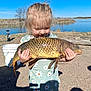 Savannah is registered to the contest to win money with this photo: child, girl, fish, carp, lake, outdoors, bucket, shore, sand, blue_sky, sunny, daisy_dress, holding, catch, smile, portrait, shadow, hair, camping_lantern, water