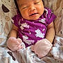 baby, infant, sleeping, purple_onesie, unicorn_pattern, mittens, blanket, cozy, newborn, cute, face, smile, human, child, indoor, soft_lighting, portrait, wrapped, peaceful, resting