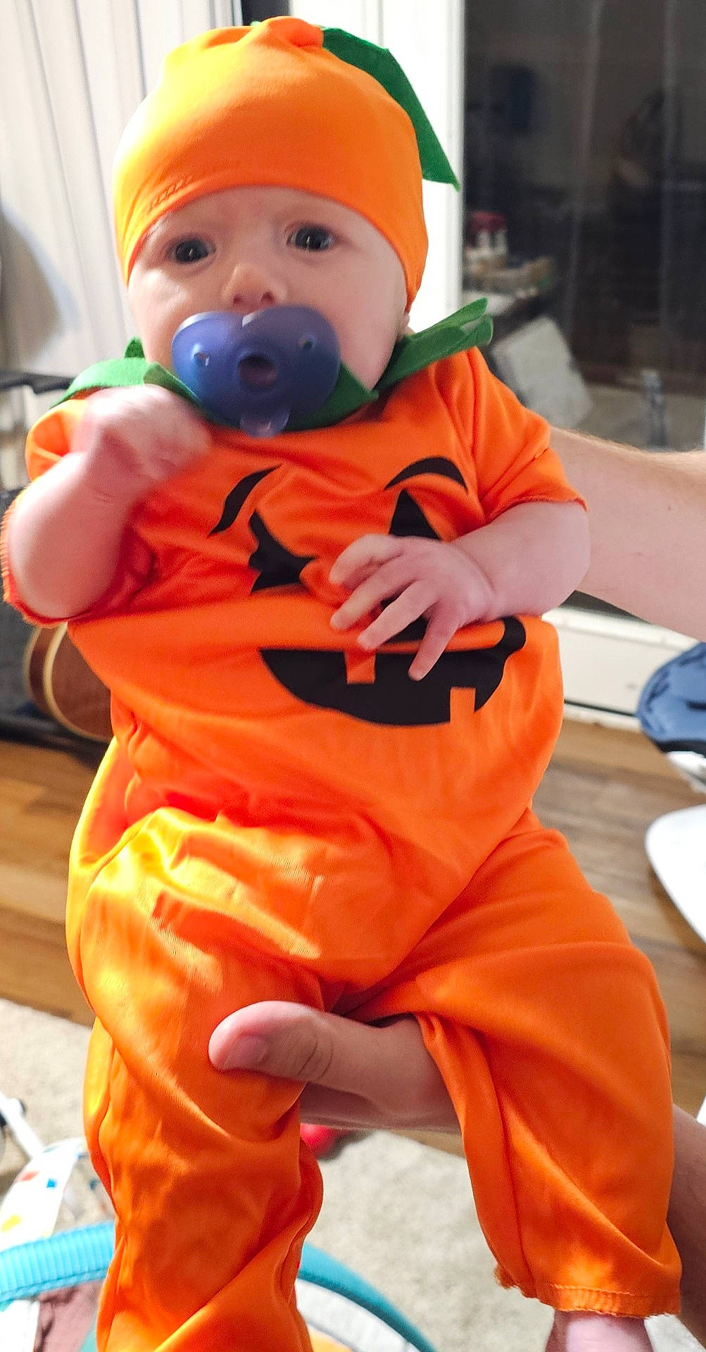 Avacyn joined the competition — help win amazing prizes! baby, carpet, child, clothing, costume, cute, face, floor, furniture, hands, headwear, holding, home, indoor, infant, orange, pacifier, person, portrait, pumpkin
