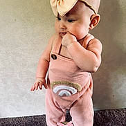 Briley is registered to the contest to win money with this photo: baby, child, infant, pink_outfit, headband, bow, standing, milestone_sign, 4_months, carpet, curious, cute, indoors, portrait, young_child, clothing, skin, face, hand, feet