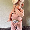 baby, child, infant, pink_outfit, headband, bow, standing, milestone_sign, 4_months, carpet, curious, cute, indoors, portrait, young_child, clothing, skin, face, hand, feet