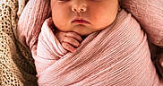 Kora is registered to the contest to win money with this photo: newborn, baby, sleeping, swaddled, pink_wrap, headband, flower, basket, blanket, cozy, soft_texture, infant, peaceful, cute, portrait, closeup, sleep, child, adorable, resting