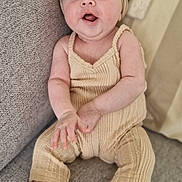 Ely participe au concours pour gagner de l'argent avec cette photo : baby, infant, couch, headband, smiling, clothing, footwear, indoors, person, cute, happy, sitting, fabric, texture, soft, child, portrait, cozy, beige, relaxing