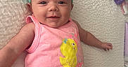 Madilynn joined the competition — help win amazing prizes! baby, infant, headband, bow, pink_tank_top, yellow_shorts, chick_design, smiling, lying_down, blanket, purple_blanket, white_bedspread, cute, happy, child, person, indoors, soft_lighting, closeup, casual_clothing