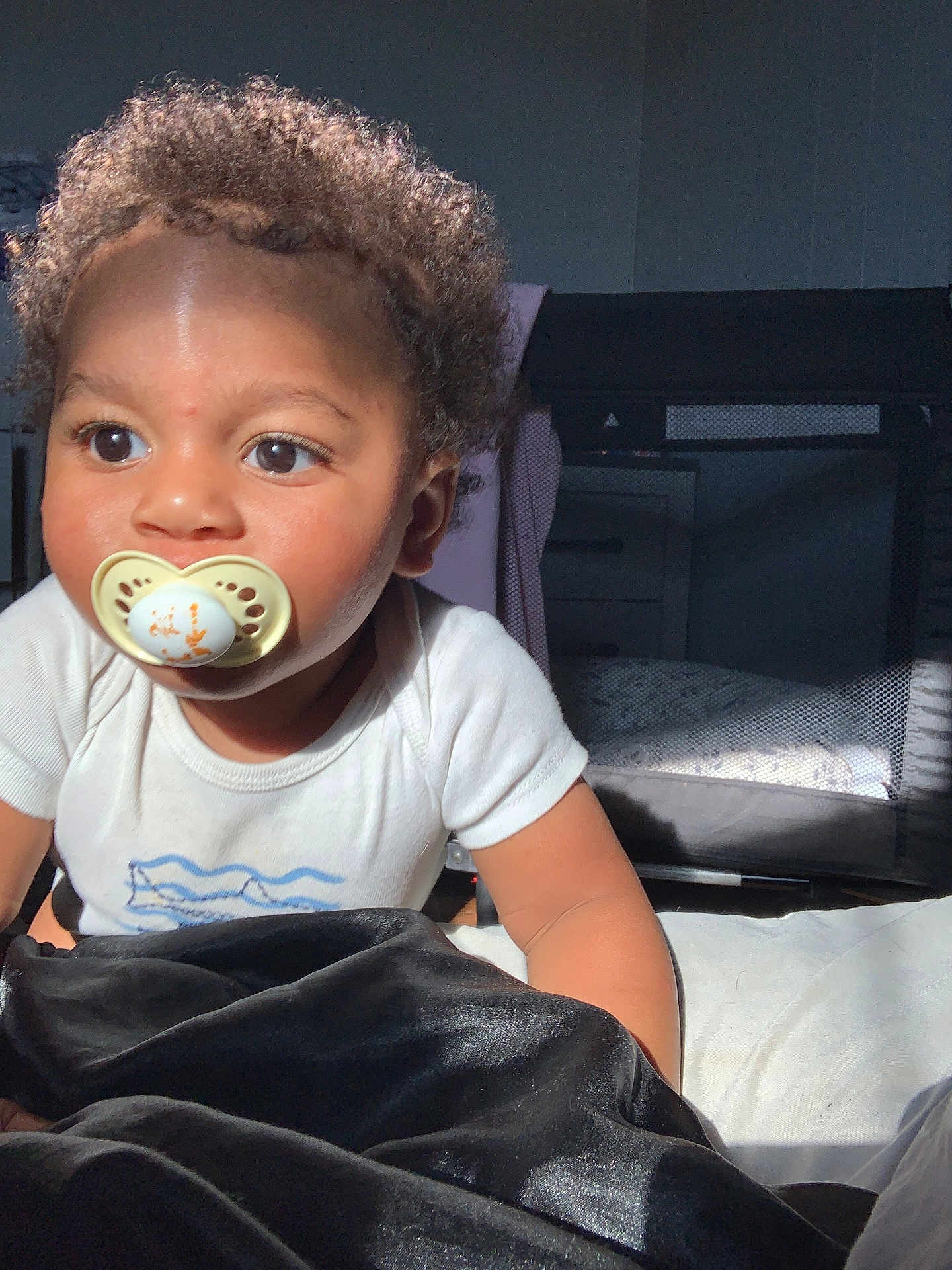 Dior joined the competition — help win amazing prizes! toddler, child, pacifier, curly_hair, white_shirt, bed, blanket, indoor, playpen, furniture, light, shadow, face, eyes, skin, crawling, infant, young_child, cute, portrait