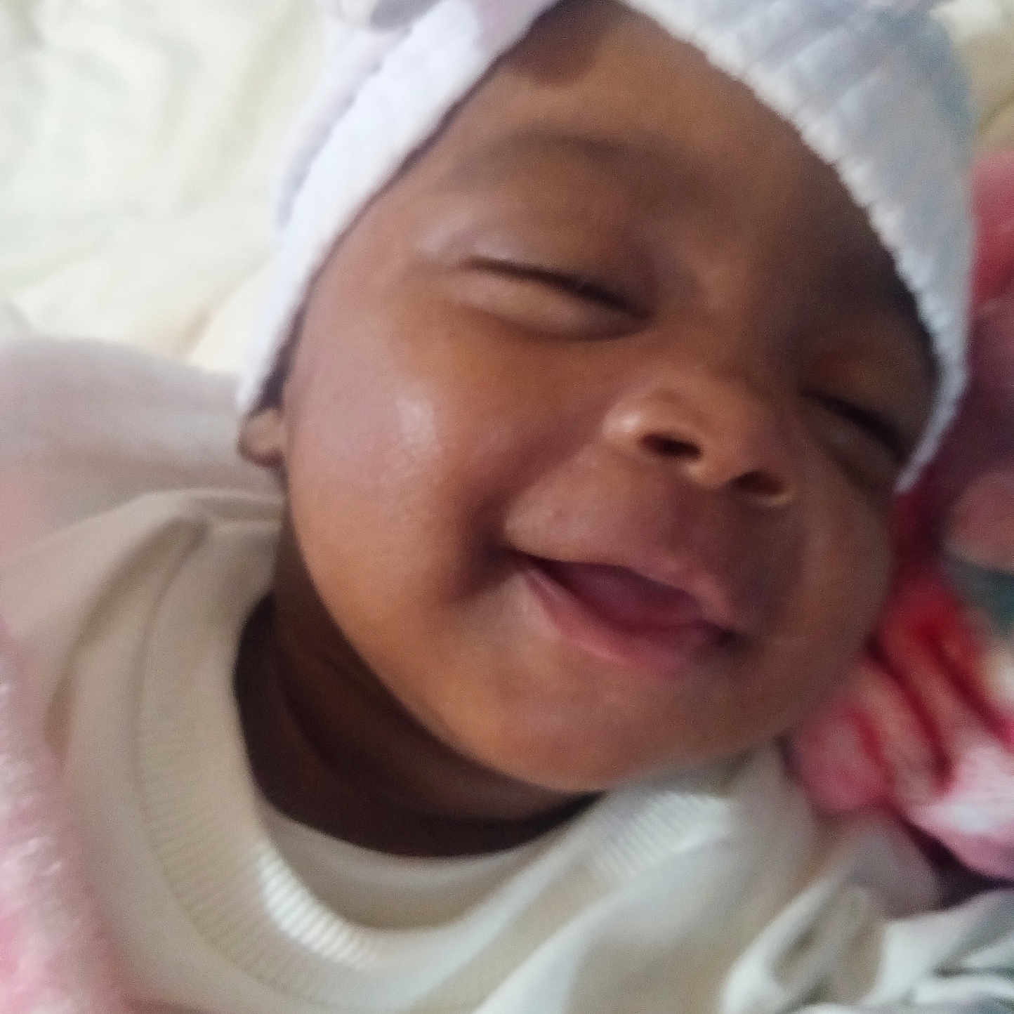 Majesty is registered to the contest to win money with this photo: architecture, baby, blanket, bodypart, bonnet, cap, clothing, face, happy, hat, head, laughing, mouth, newborn, person, photography, portrait, sleeping, smile, towel