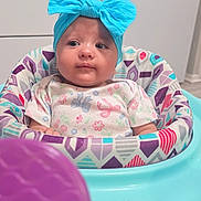 Rosalena joined the competition — help win amazing prizes! baby, headband, blue_bow, baby_seat, patterned_fabric, toy, purple_toy, infant, child, indoors, kitchen_background, colorful, cute, toddler, seated, clothing, face, expression, young_child, portrait
