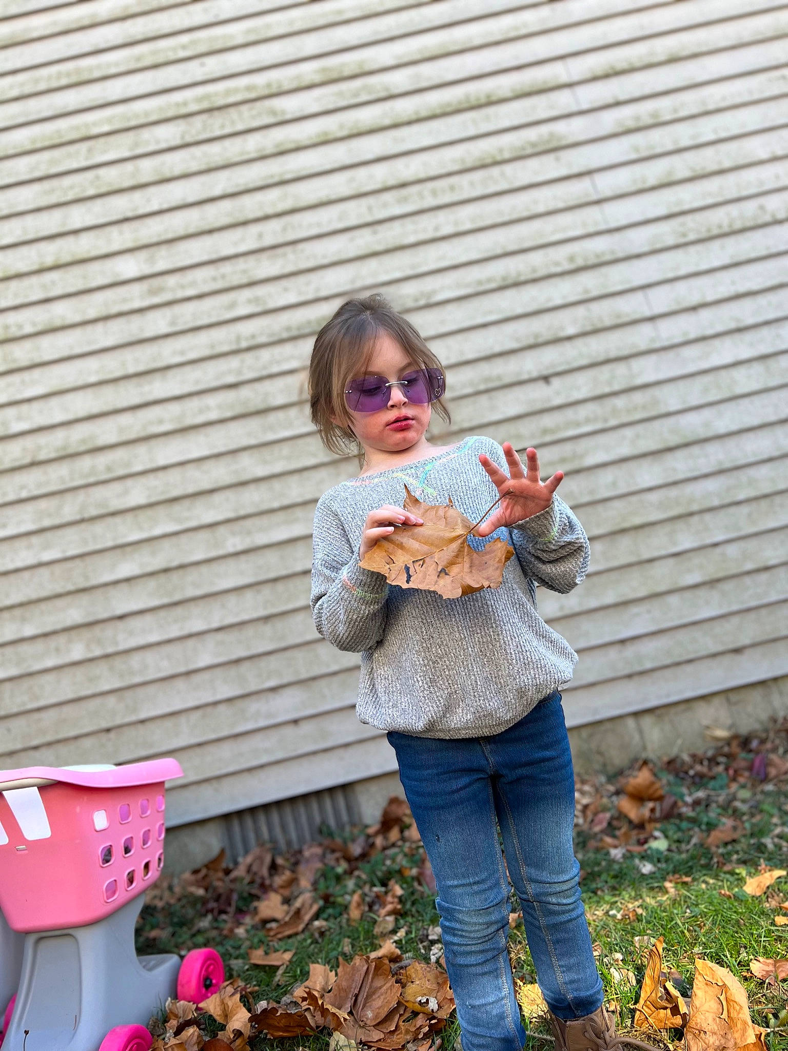 Andi is registered to the contest to win money with this photo: brick, brickwork, child, denim, eyewear, fruit, fur, garden, goggles, grass, orange, pattern, peach, person, pink, plant, sitting, soil, sunglasses, winter