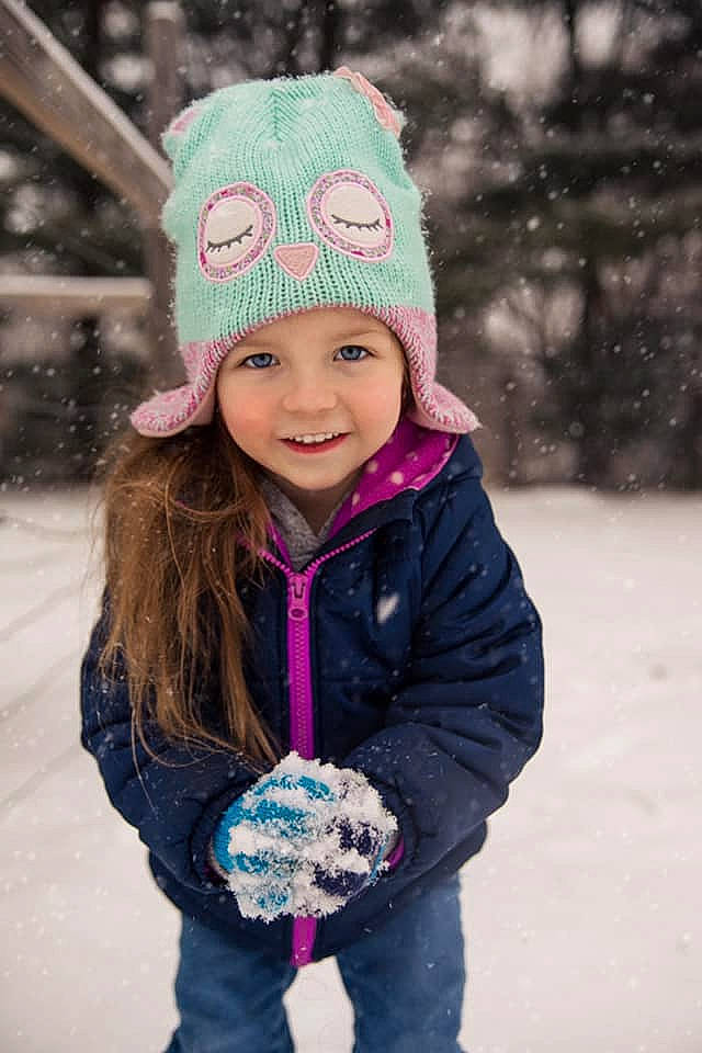 Mira is registered to the contest to win money with this photo: beanie, bonnet, cap, child, clothing, cool, crochet, freezing, fun, headgear, joy, knit_cap, outerwear, person, pink, play, playing_in_the_snow, purple, smile, snow