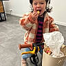 child, helmet, bike, snack, indoor, jacket, cozy, basket, toy, happy, smiling, floor, playful, shoes, person, casual, young, cute, fun, activity