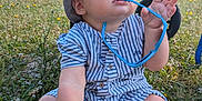 Noé participe au concours pour gagner de l'argent avec cette photo : baby, child, grass, outdoor, sunhat, romper, blue_eyes, sunglasses, chewing, stroller, nature, daylight, summer, field, legs, hands, face, curious, sitting, clothing