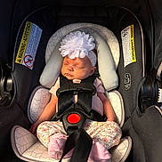 Eliana is registered to the contest to win money with this photo: baby, infant, car_seat, flower_headband, sleeping, child, pink_socks, floral_pants, safety_harness, cushion, close_up, indoors, peaceful, cute, newborn, portrait, seat_belt, head_support, adorable, child_safety