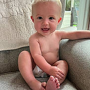 Isla is registered to the contest to win money with this photo: baby, blonde, bodypart, couch, cushion, face, finger, furniture, hair, hand, happy, head, homedecor, indoors, laughing, person, photography, portrait, sitting, smile