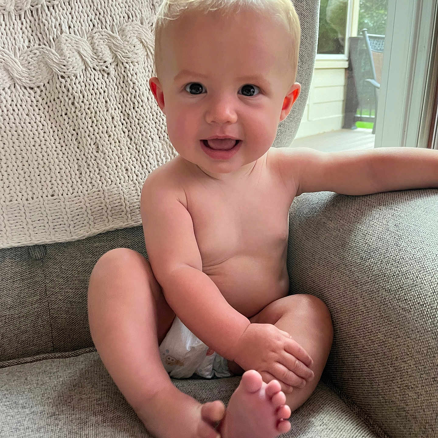 Isla is registered to the contest to win money with this photo: baby, blonde, bodypart, couch, cushion, face, finger, furniture, hair, hand, happy, head, homedecor, indoors, laughing, person, photography, portrait, sitting, smile