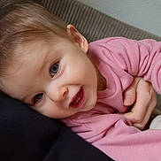 Ava a rejoint le concours — aidez-le/la à gagner de superbes lots ! baby, child, pink_clothing, smiling, face, blue_eyes, hand, couch, cozy, snuggling, infant, closeup, happy, skin, cheeks, person, indoors, head, young_child, casual