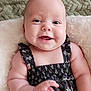 baby, smiling, infant, black_dress, floral_pattern, blanket, soft_texture, happy, cute, chubby_cheeks, lying_down, person, child, closeup, indoors, skin, arm, hand, portrait, head