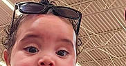 Alani joined the competition — help win amazing prizes! baby, child, indoor, jacket, sunglasses, hand, person, curious, face, portrait, expression, clothing, ceiling, metal_beams, holding, looking, young, cute, casual, black_shirt