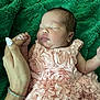 baby, newborn, sleeping, pink_dress, ruffles, hand, adult_hand, bracelet, manicure, green_blanket, fabric, texture, portrait, cute, infant, peaceful, soft, closeup, resting, person