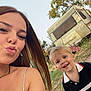 caravan, casual_clothing, child, daylight, face, grass, greenery, hair, happy, nature, outdoor, person, portrait, selfie, sky, smile, trees, vacation, woman, young_child