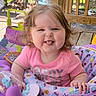 Chloe is registered to the contest to win money with this photo: baby, child, smiling, tongue_out, pink_shirt, activity_center, toy, curly_hair, outdoor, deck, wooden_floor, colorful, happy, playful, person, infant, seat, daylight, cute, fun