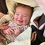 baby, smiling, blanket, cozy, cute, infant, hand, person, clothing, fabric, pink, brown, soft, happy, face, closeup, indoors, seat, carseat, cute_expression
