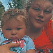 Kinsley is registered to the contest to win money with this photo: baby, child, woman, outdoor, sky, trees, selfie, portrait, person, holding, clothing, orange_top, blue_shirt, hand, face, expression, nature, daylight, casual, fun