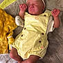 baby, sleeping, yellow_romper, headband, bow, blanket, plush_toy, hand, infant, soft_texture, clothing, cute, peaceful, newborn, resting, indoors, person, skin, foot, hand_holding