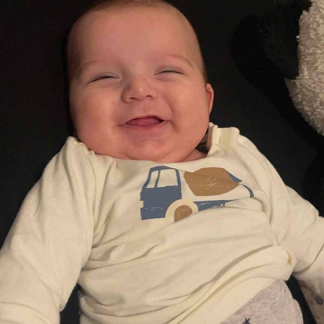 Myke a rejoint le concours — aidez-le/la à gagner de superbes lots ! baby, buttoned_pants, cheeks, child, clothing, cute, face, happy, indoor, infant, joyful, patterned_clothing, person, plush_toy, relaxed, shirt, sitting, smiling, soft_toy, young_child