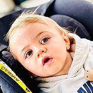 Orphee a rejoint le concours — aidez-le/la à gagner de superbes lots ! toddler, child, face, eyes, hoodie, car_seat, seatbelt, airbag_label, curious, close_up, young_child, casual_clothing, indoor, infant, portrait, baby, head, expression, seat, safety