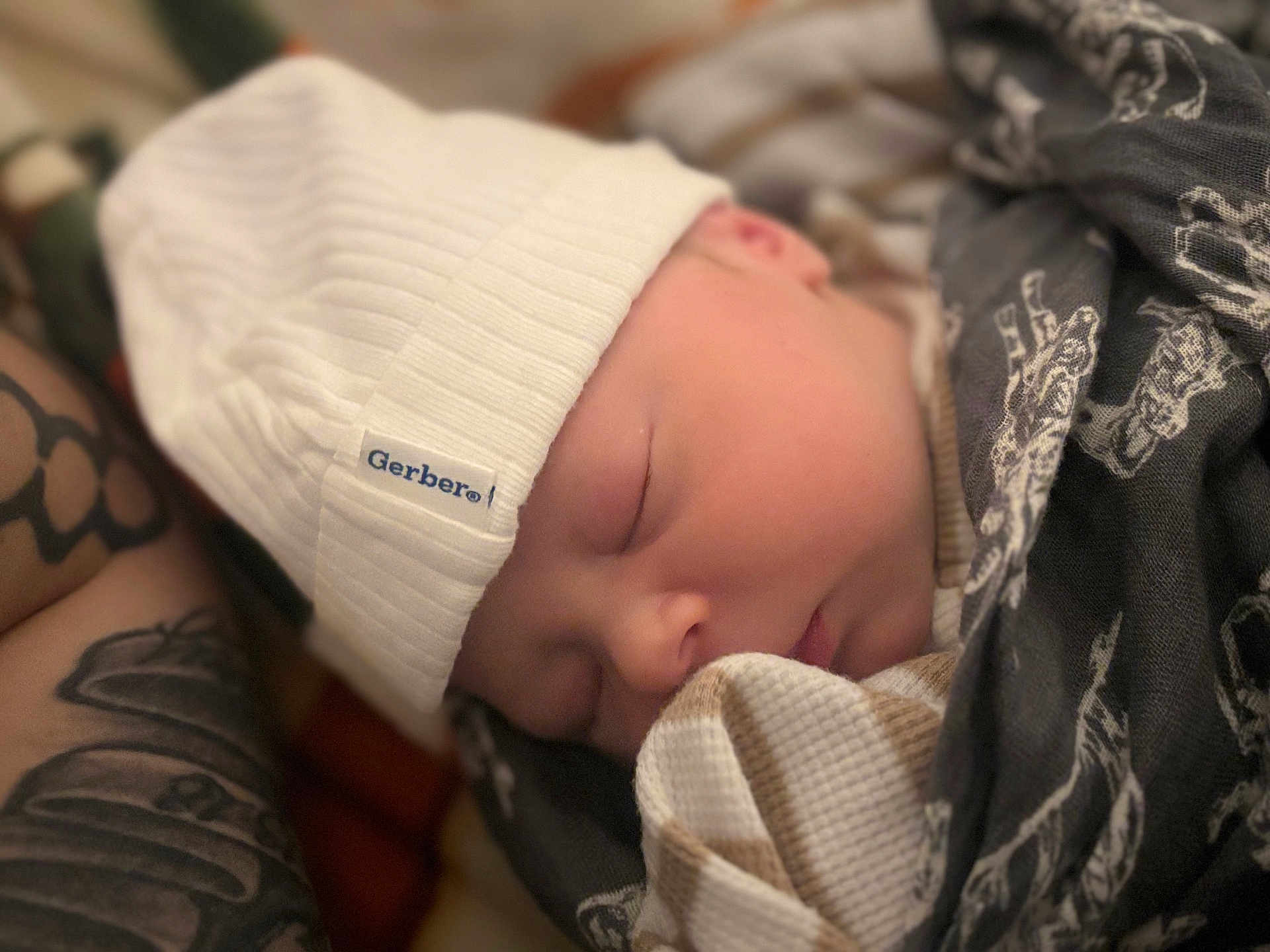 Hudson Bear joined the competition — help win amazing prizes! newborn, baby, sleeping, hat, white_hat, blanket, tattoo, arm, closeup, cozy, infant, peaceful, soft_focus, wrapped, portrait, human, skin, face, child, indoors