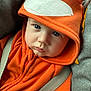 baby, child, hoodie, orange_clothing, fox_design, blue_eyes, car_seat, seatbelt, close_up, cute, infant, face, expression, soft_lighting, casual, warm_clothing, indoors, portrait, young_child, sitting