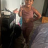 Athena is registered to the contest to win money with this photo: child, indoor, smiling, pose, clothing, sneakers, shorts, top, floor, bed, room, casual, person, happy, young, standing, home, hair, skin, accessory