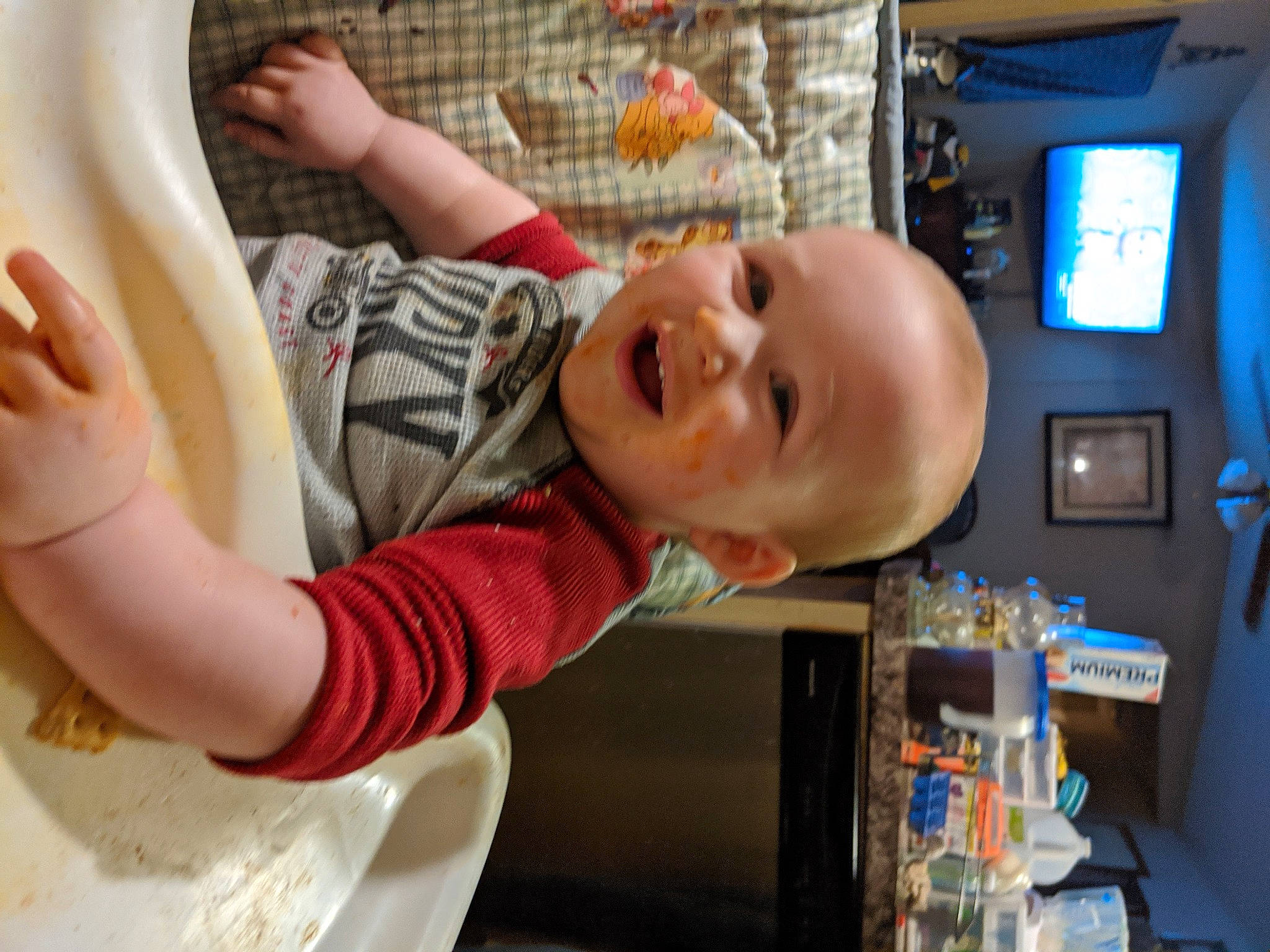 Caleb is registered to the contest to win money with this photo: baby, baby_products, chair, child, comfort, finger, food, fun, hand, happy, leisure, person, play, room, sitting, smile, t_shirt, table, thumb, toddler