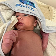 Alejandro participe au concours pour gagner de l'argent avec cette photo : baby, infant, newborn, towel, hood, stitch, blue, skin, face, hand, blanket, soft, cute, lying_down, indoors, expression, curious, young_child, portrait, resting