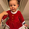 baby, blanket, changing_table, cheeks, child, christmas_outfit, clothing, cute, eyes, face, hand, holiday, indoor, person, plush, portrait, red_dress, smile, toddler, window