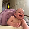 baby, child, high_chair, laughing, smiling, indoor, furniture, purple, person, happy, arm, face, expression, skin, head, table, room, door, laundry_basket, home