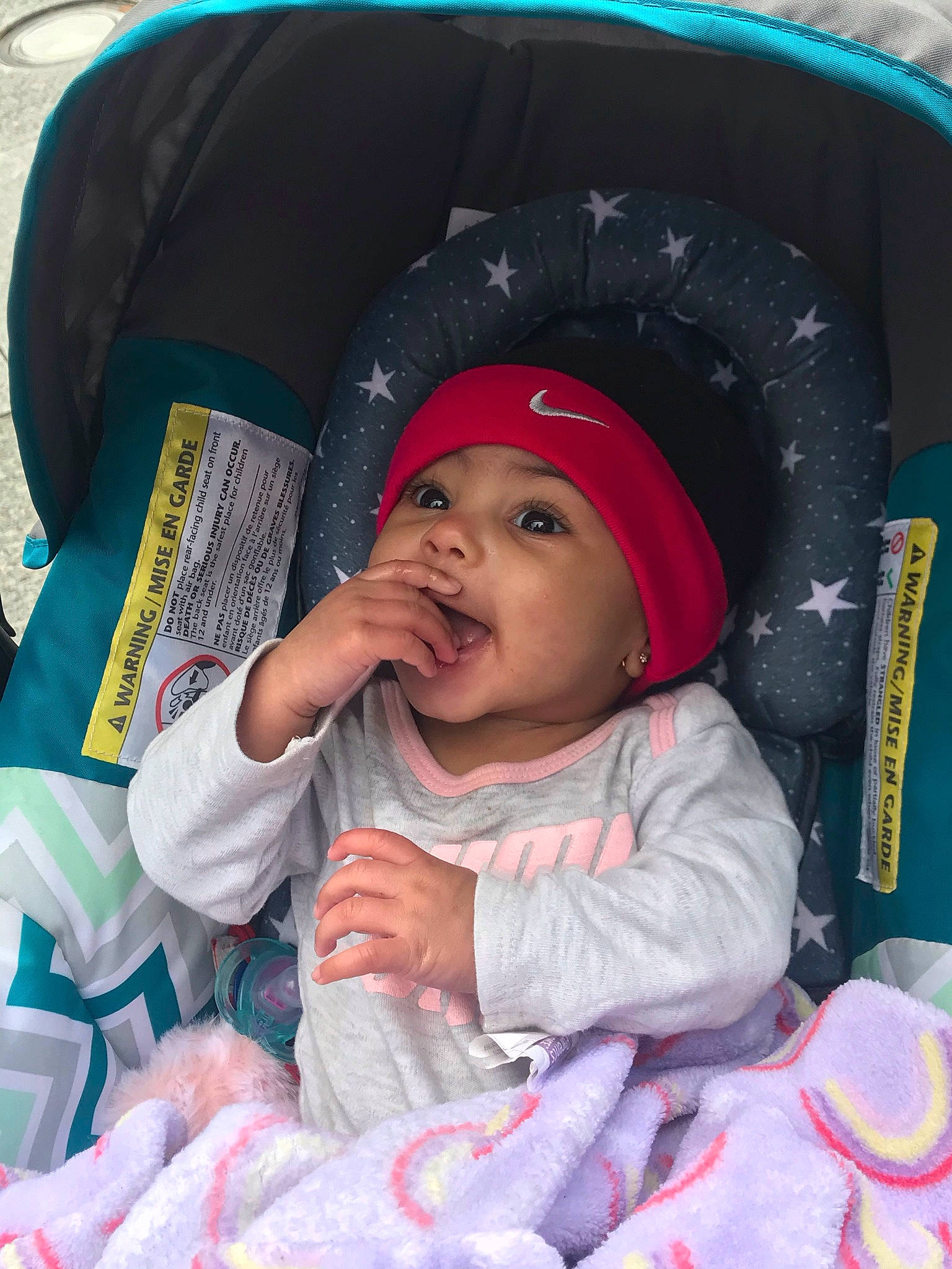 Harmony is registered to the contest to win money with this photo: automotive_tire, baby, baby_carriage, baby_toddler_clothing, car_seat, child, comfort, eye, fun, hat, head, headwear, helmet, human_body, person, pink, purple, skin, tire, toddler