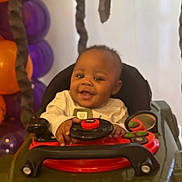 Nova joined the competition — help win amazing prizes! baby, balloons, celebration, child, clothing, face, happy, indoor, infant, mirror, orange_balloons, party, person, playful, purple_balloons, seat, smile, steering_wheel, toy_car, young_child