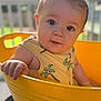 baby, child, yellow_bucket, tank_top, palm_tree_print, curious, portrait, indoors, hand, face, skin, cute, expression, short_hair, summer_clothing, natural_light, background_blur, person, infant, closeup
