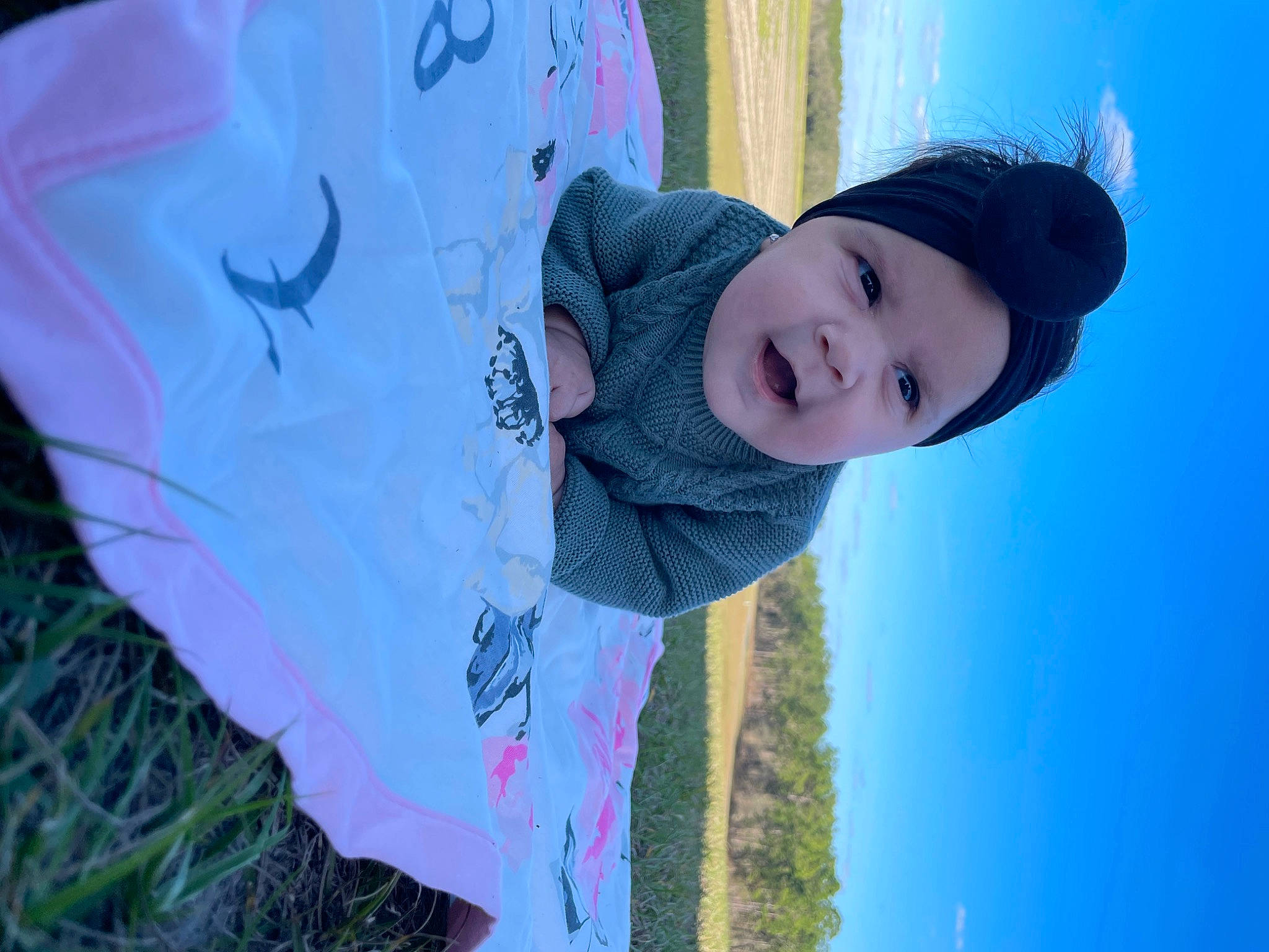Elliana is registered to the contest to win money with this photo: baby, cap, child, electric_blue, fashion_accessory, flash_photography, fun, grass, happy, headwear, leisure, linens, outerwear, pattern, people_in_nature, person, plant, portrait_photography, sky, sun_hat