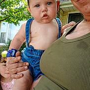 Wilson is registered to the contest to win money with this photo: adult, baby, child, children, denim, face, family, family_photo, garden, green_shirt, holding, house, infant, outdoor, overalls, portrait, smiling, sunlight, toddler, trees